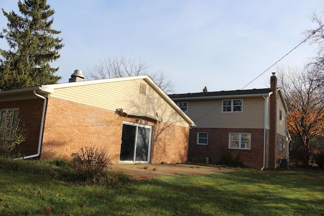 9370 Moon Rd, Saline, MI 48176 - rear view of property featuring a chimney, brick siding, central AC unit, and a yard