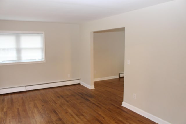 9370 Moon Rd, Saline, MI 48176 - empty room featuring a baseboard heating unit, wood finished floors, and baseboards