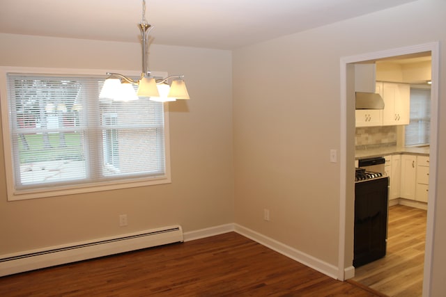 unfurnished dining area featuring baseboard heating, hardwood / wood-style floors, and an inviting chandelier