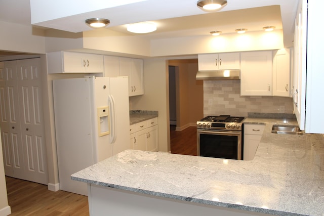 9370 Moon Rd, Saline, MI 48176 - kitchen with stainless steel gas range, white fridge with ice dispenser, under cabinet range hood, light stone countertops, and a peninsula
