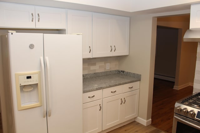 kitchen with hardwood / wood-style floors, white refrigerator with ice dispenser, a baseboard heating unit, decorative backsplash, and white cabinetry