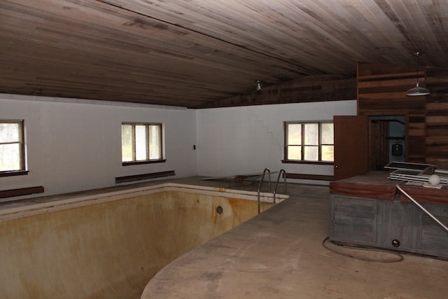 interior space with plenty of natural light, wood ceiling, vaulted ceiling, and a baseboard heating unit