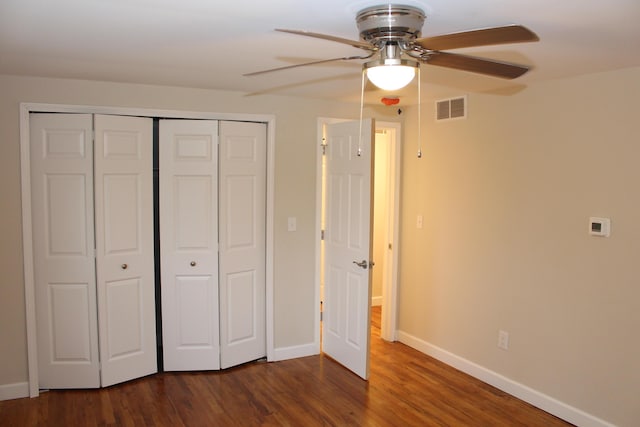 9370 Moon Rd, Saline, MI 48176 - unfurnished bedroom with a closet, baseboards, dark wood-style flooring, and ceiling fan