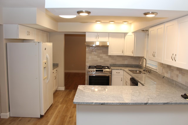 9370 Moon Rd, Saline, MI 48176 - kitchen with white refrigerator with ice dispenser, stainless steel gas stove, under cabinet range hood, a sink, and a peninsula