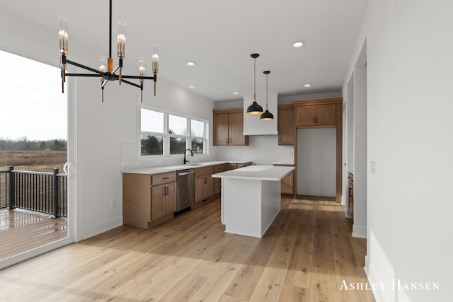 kitchen with light wood-type flooring, stainless steel dishwasher, a notable chandelier, a center island, and hanging light fixtures