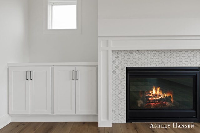 interior details with a tile fireplace and hardwood / wood-style flooring