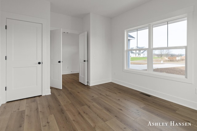 unfurnished bedroom with hardwood / wood-style flooring