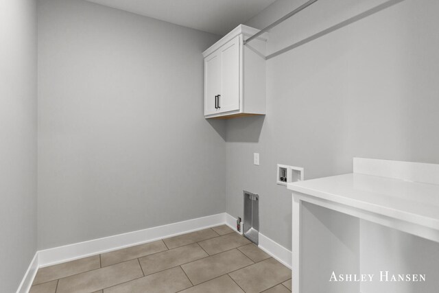 washroom featuring light tile patterned floors, cabinets, and washer hookup