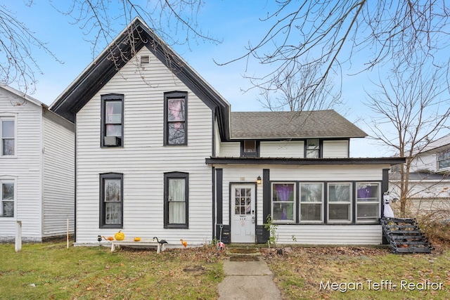 view of front facade featuring a front yard and a sunroom