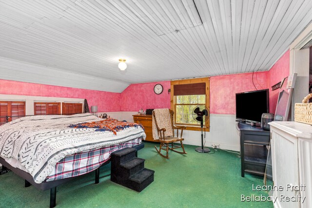 carpeted bedroom with lofted ceiling