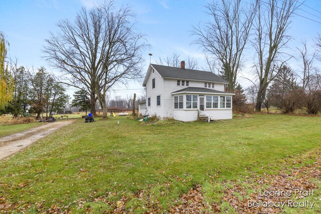 view of property exterior with a sunroom and a yard