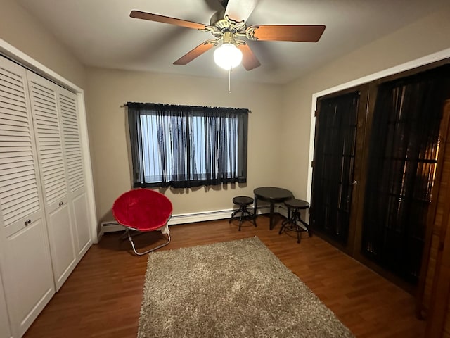 living area featuring ceiling fan, dark hardwood / wood-style flooring, and baseboard heating