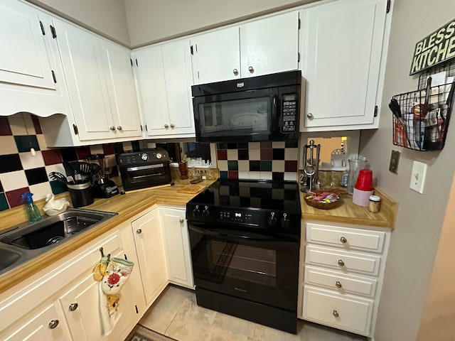 kitchen with decorative backsplash, sink, black appliances, light tile patterned floors, and white cabinets