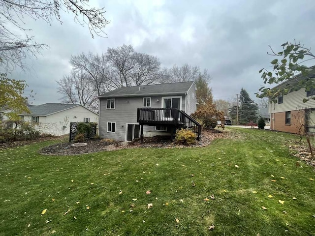 back of property with a yard and a wooden deck