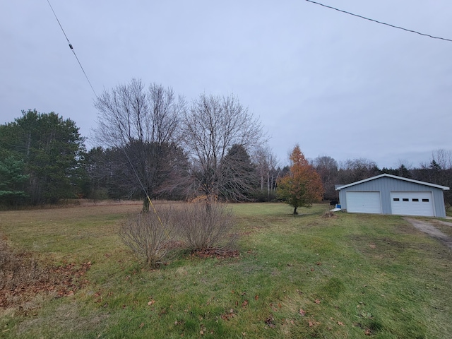 view of yard with a garage and an outbuilding