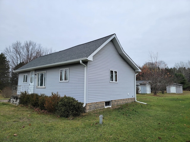 view of side of property with a yard and a shed