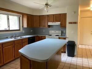 kitchen featuring ceiling fan, a kitchen island, light tile patterned floors, and white electric stove