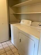 clothes washing area featuring separate washer and dryer and light tile patterned floors