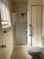 bathroom featuring vanity, toilet, and a shower with shower door