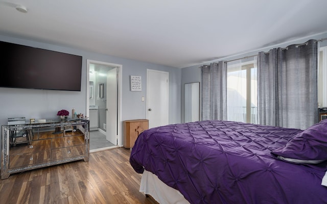 bedroom featuring ensuite bathroom and dark wood-type flooring