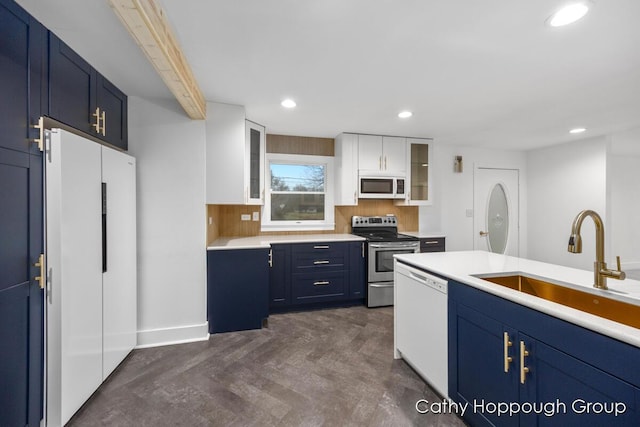 kitchen featuring blue cabinetry, sink, white cabinets, and white appliances