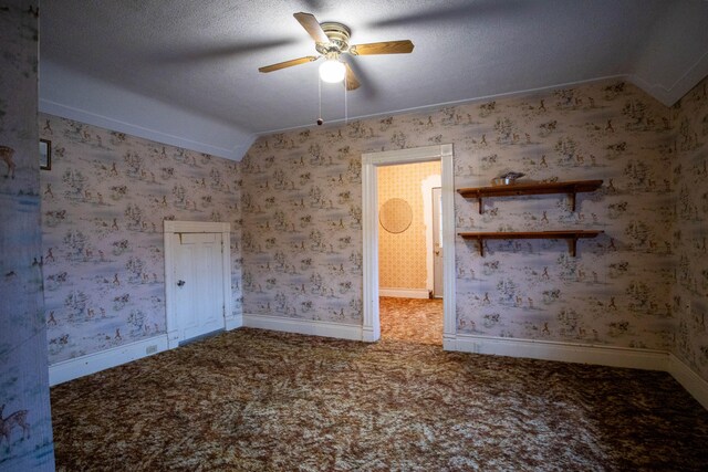 carpeted empty room with ceiling fan, ornamental molding, lofted ceiling, and a textured ceiling