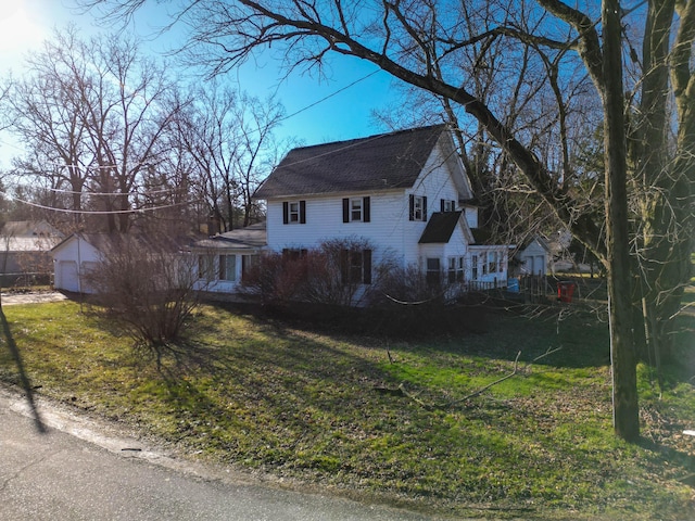 view of home's exterior featuring a lawn, an outbuilding, and a garage