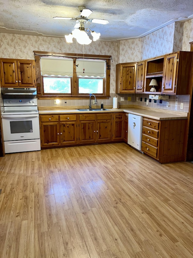 kitchen featuring sink, white appliances, a textured ceiling, and backsplash