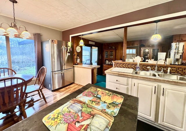 kitchen featuring stainless steel fridge, dark wood-type flooring, sink, white cabinets, and a center island