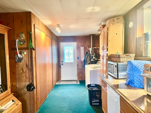 interior space featuring wood walls, dark carpet, and separate washer and dryer