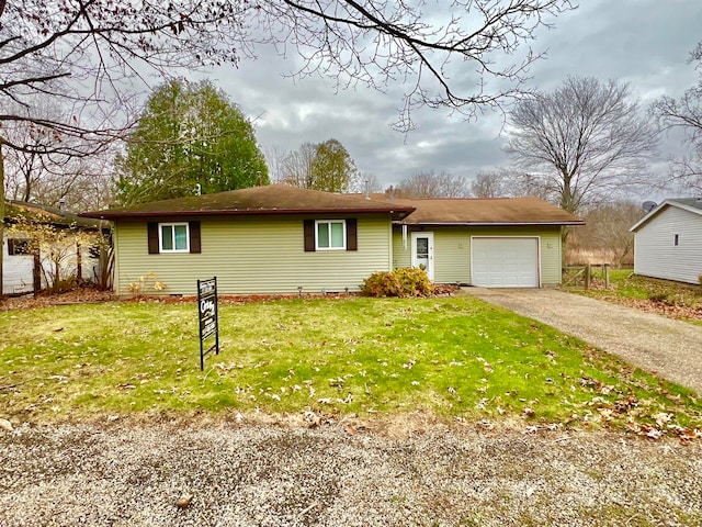 ranch-style home featuring a front lawn and a garage