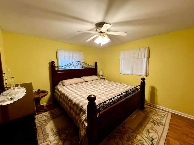 bedroom with dark hardwood / wood-style flooring and ceiling fan