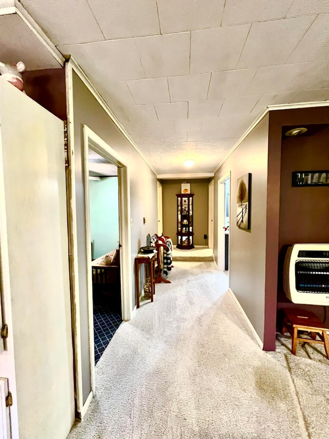 hall featuring carpet flooring, heating unit, and crown molding