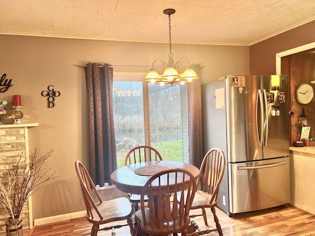 dining room featuring a chandelier, crown molding, and light hardwood / wood-style flooring