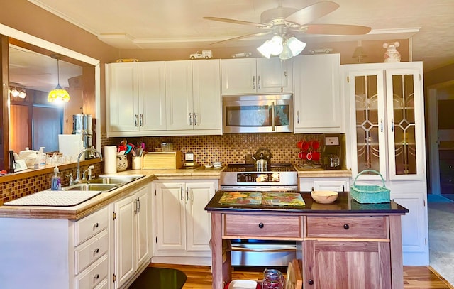 kitchen featuring backsplash, white cabinets, sink, light hardwood / wood-style floors, and stainless steel appliances