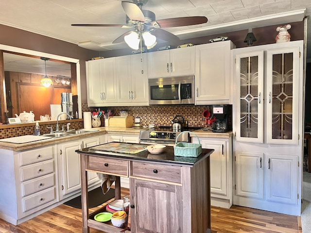 kitchen with sink, stainless steel appliances, tasteful backsplash, light hardwood / wood-style floors, and white cabinets