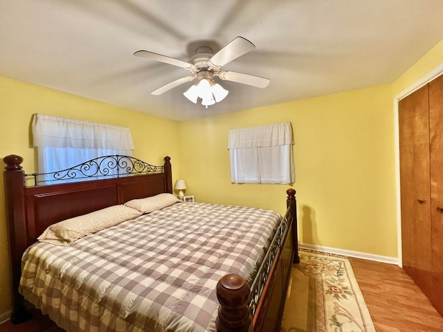 bedroom featuring ceiling fan, a closet, and light hardwood / wood-style flooring