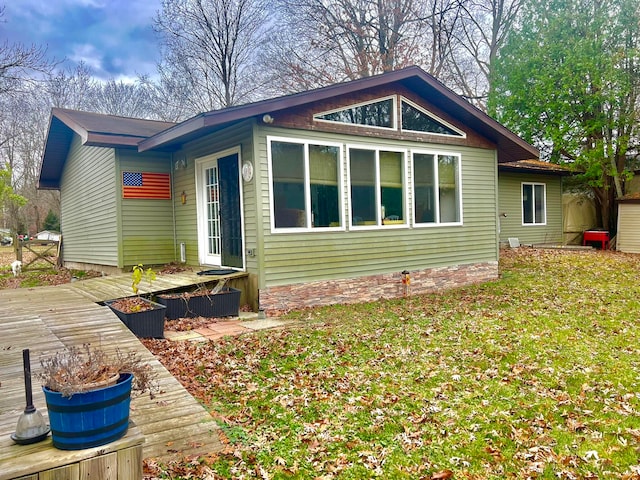 view of side of property with a lawn and a wooden deck