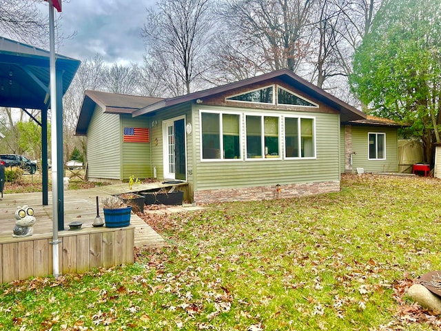 view of home's exterior with a lawn and a deck