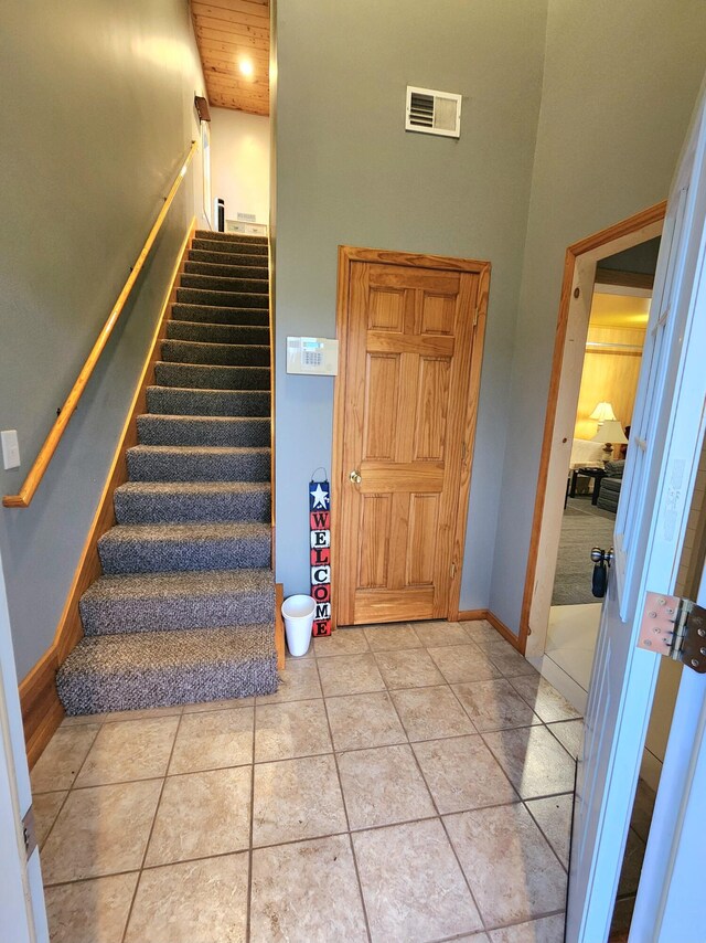 stairs featuring tile patterned flooring and a towering ceiling