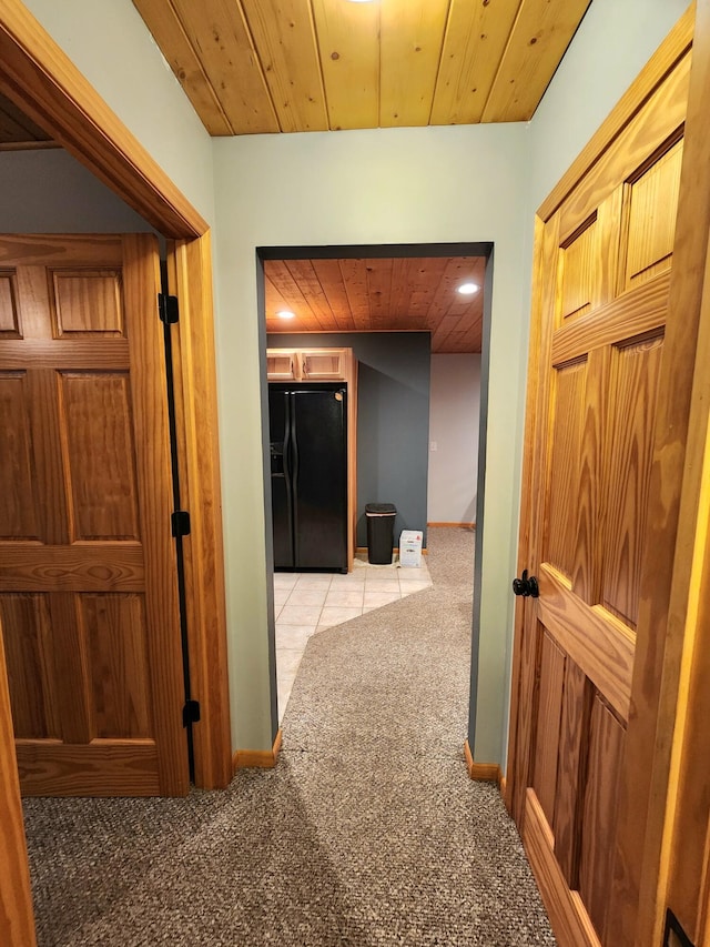 corridor featuring light colored carpet and wooden ceiling