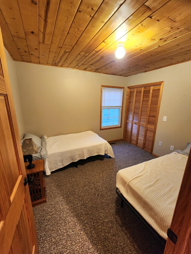 bedroom with a closet, carpet, and wood ceiling