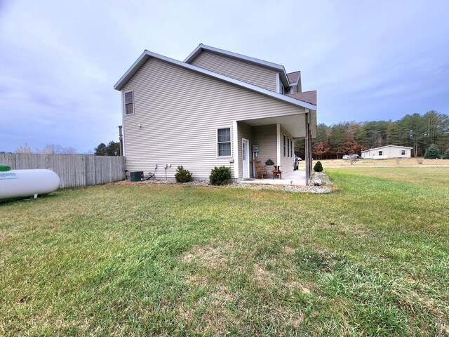 exterior space with a lawn, cooling unit, and a patio