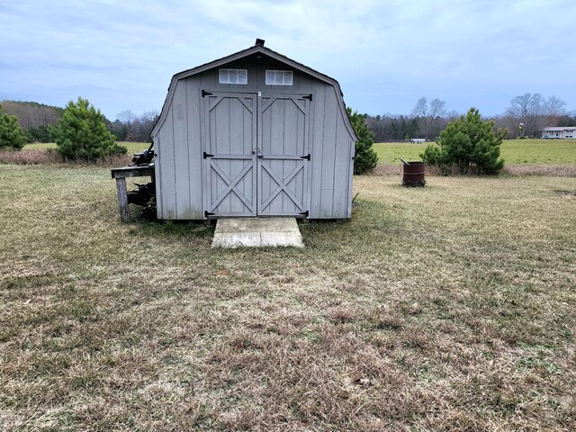 view of outdoor structure featuring a rural view and a yard