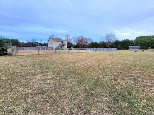 view of yard featuring a rural view and a storage unit