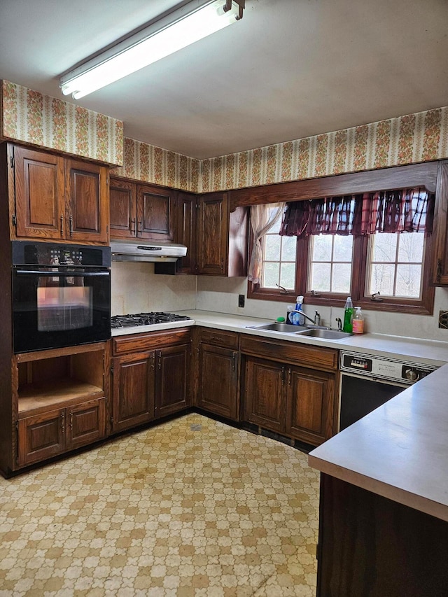 kitchen with black appliances, dark brown cabinets, and sink