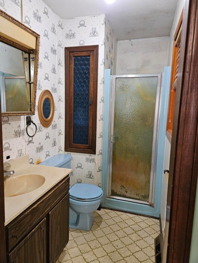 bathroom featuring toilet, vanity, and walk in shower