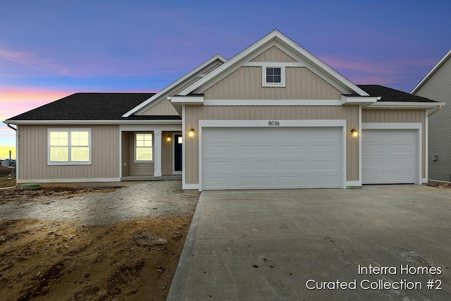 view of front of house with a shingled roof, concrete driveway, and an attached garage