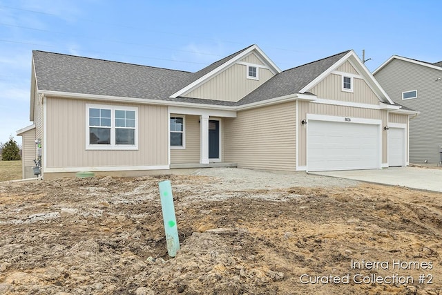 view of front of property featuring concrete driveway, roof with shingles, and an attached garage