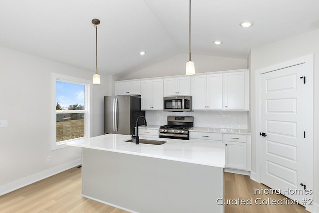 kitchen featuring stainless steel appliances, tasteful backsplash, a sink, and white cabinets